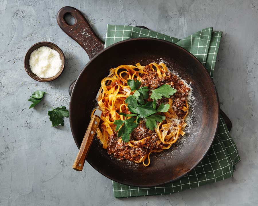 Tagliatelle med sås och parmesan i en stekpanna